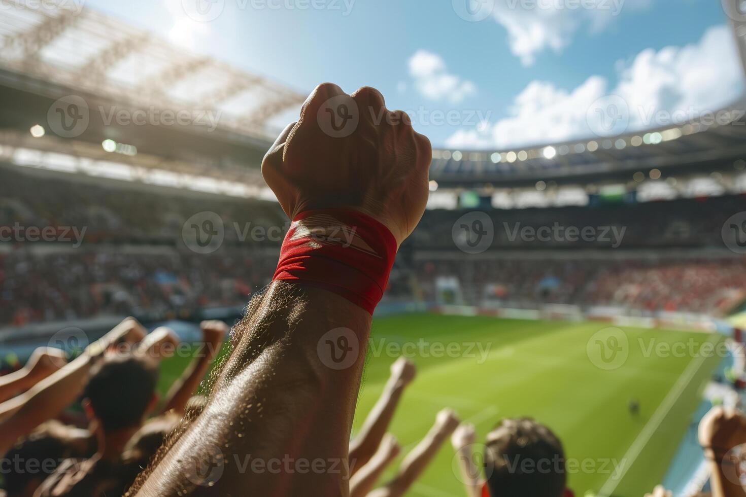 A man is holding his arm up in the air in a stadium full of people photo