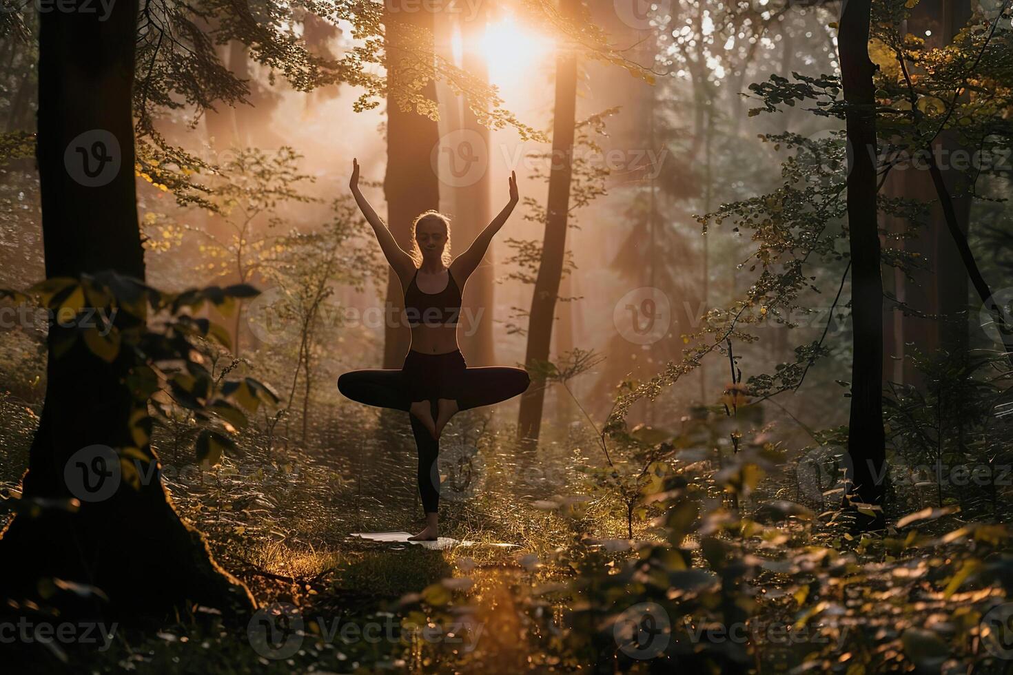 A woman is sitting in the woods, practicing yoga photo