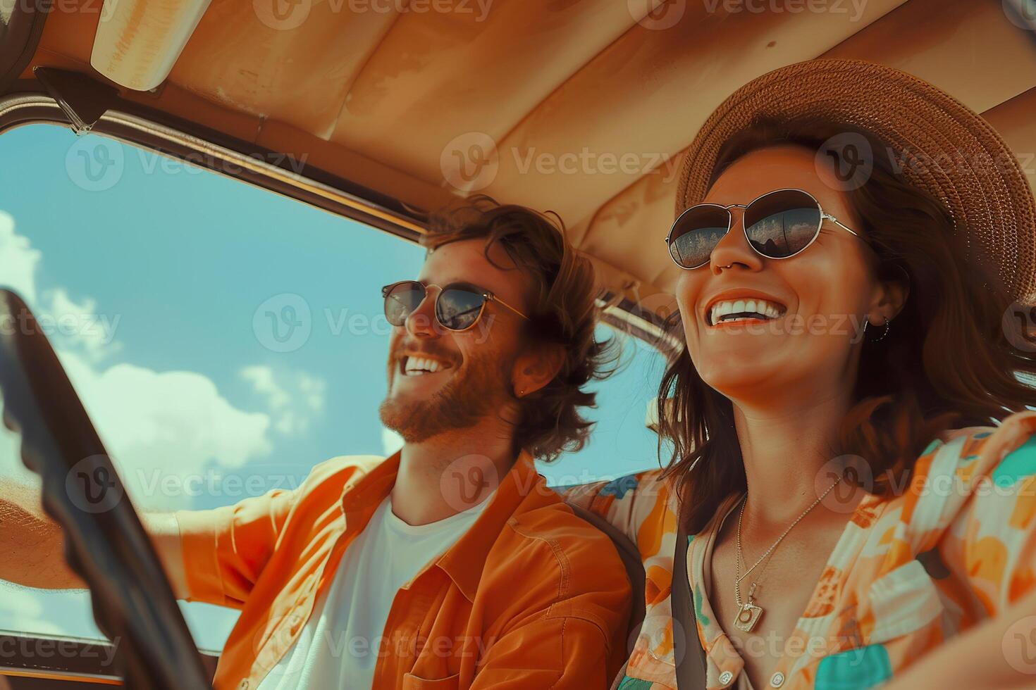 A man and a woman are smiling and laughing while driving in a car photo