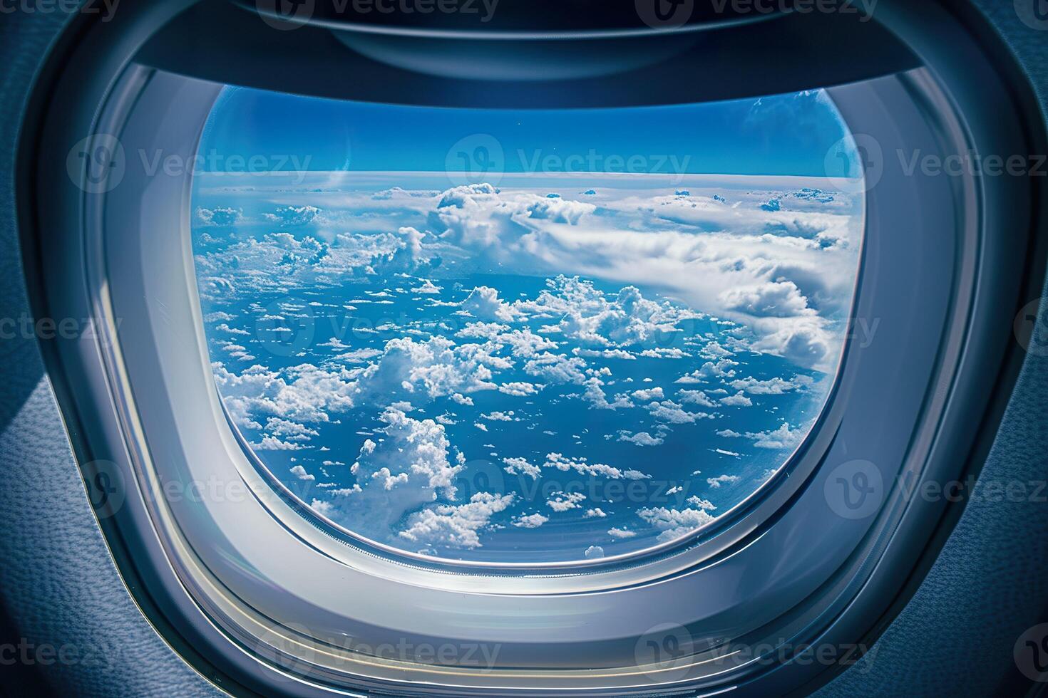 A window on an airplane with a blue sky and clouds photo