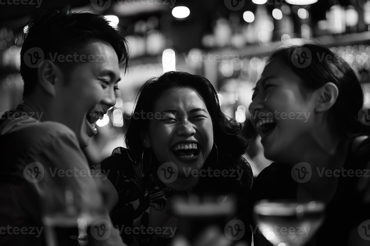 Asian adults laughing and drinking having fun at a party in a bar photo