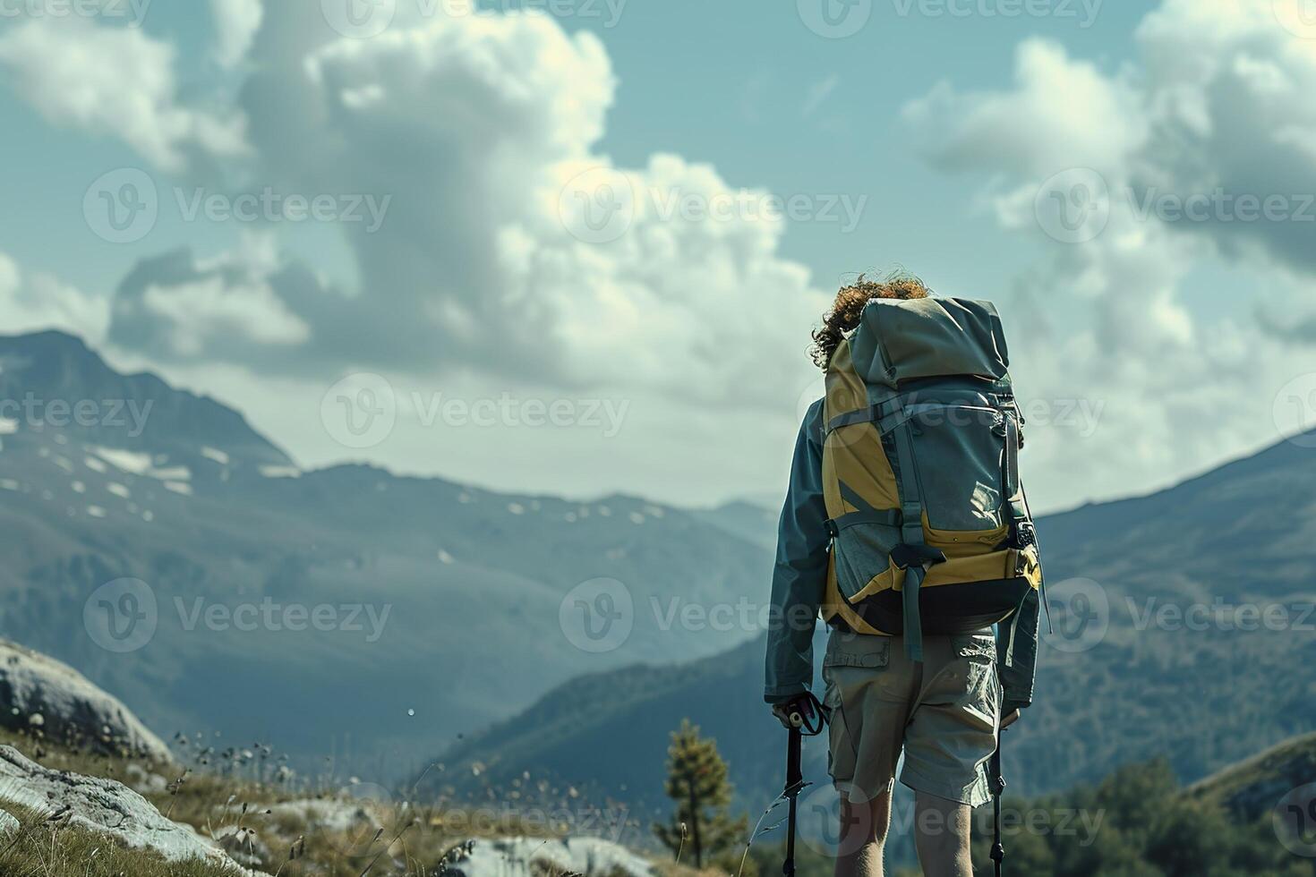 A man is walking in the woods with a backpack and a hat photo