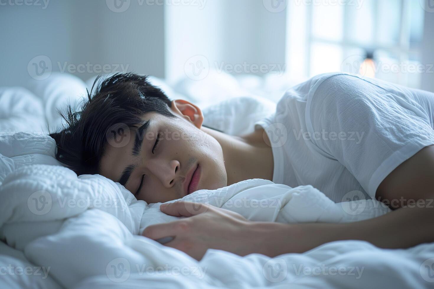 Asian man 20 yo in a white clothes laying down on white bed with white blanket, happily sleeping photo