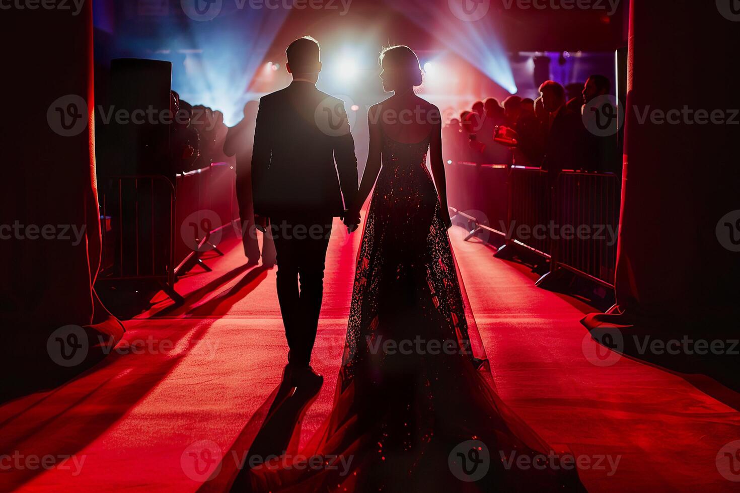 Back silhouette view of a couple of stars in gorgeous evening gowns and suit walking on the red carpet posing for awards ceremony. photo
