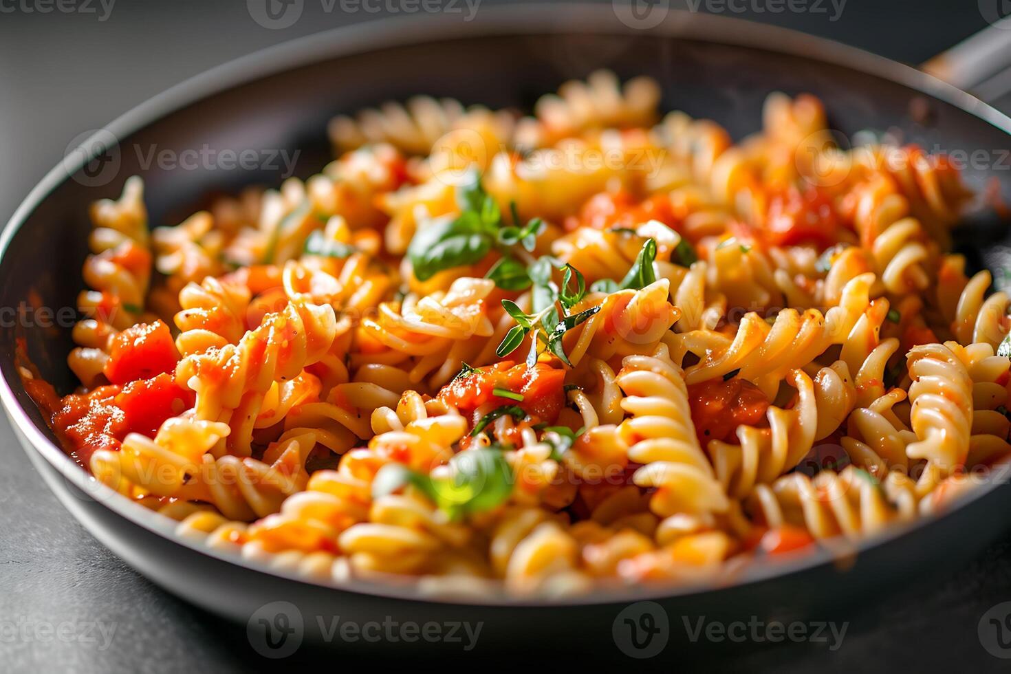 Delicious and easy pasta dish. Fusilli with tomato sauce and basil, served in a pan. Perfect for a quick and tasty meal. photo