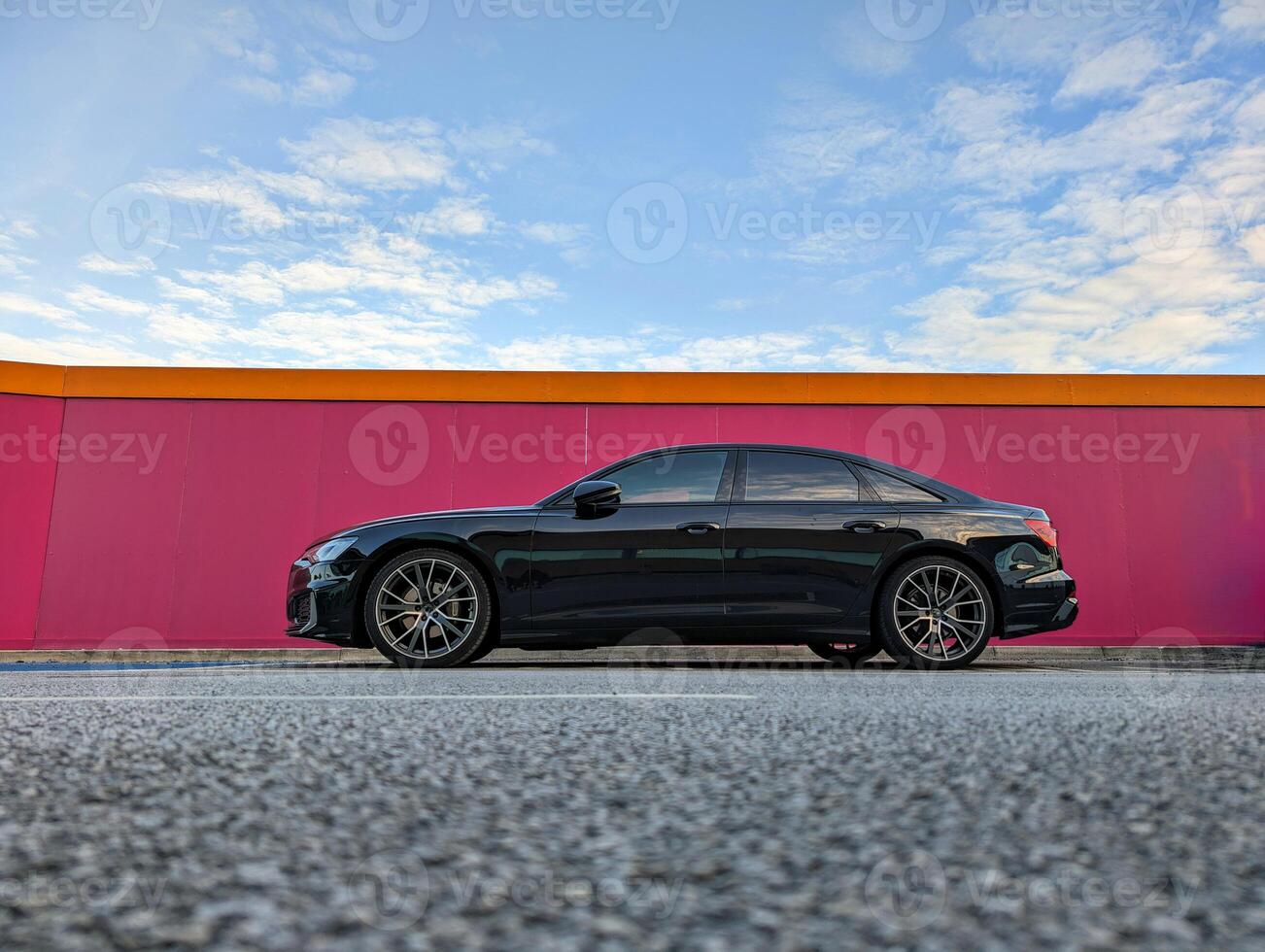 Black modern automobile parked in front of pink wall, vehicle and transport, automotive background photo