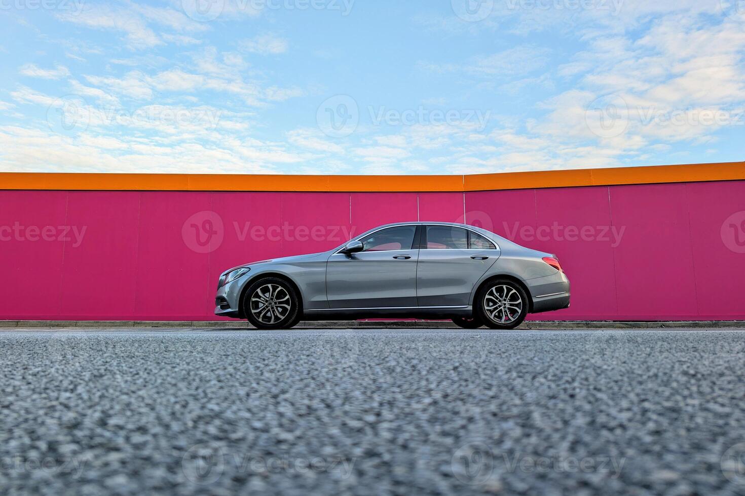 Grey modern automobile parked in front of pink wall, vehicle and transport, automotive background photo