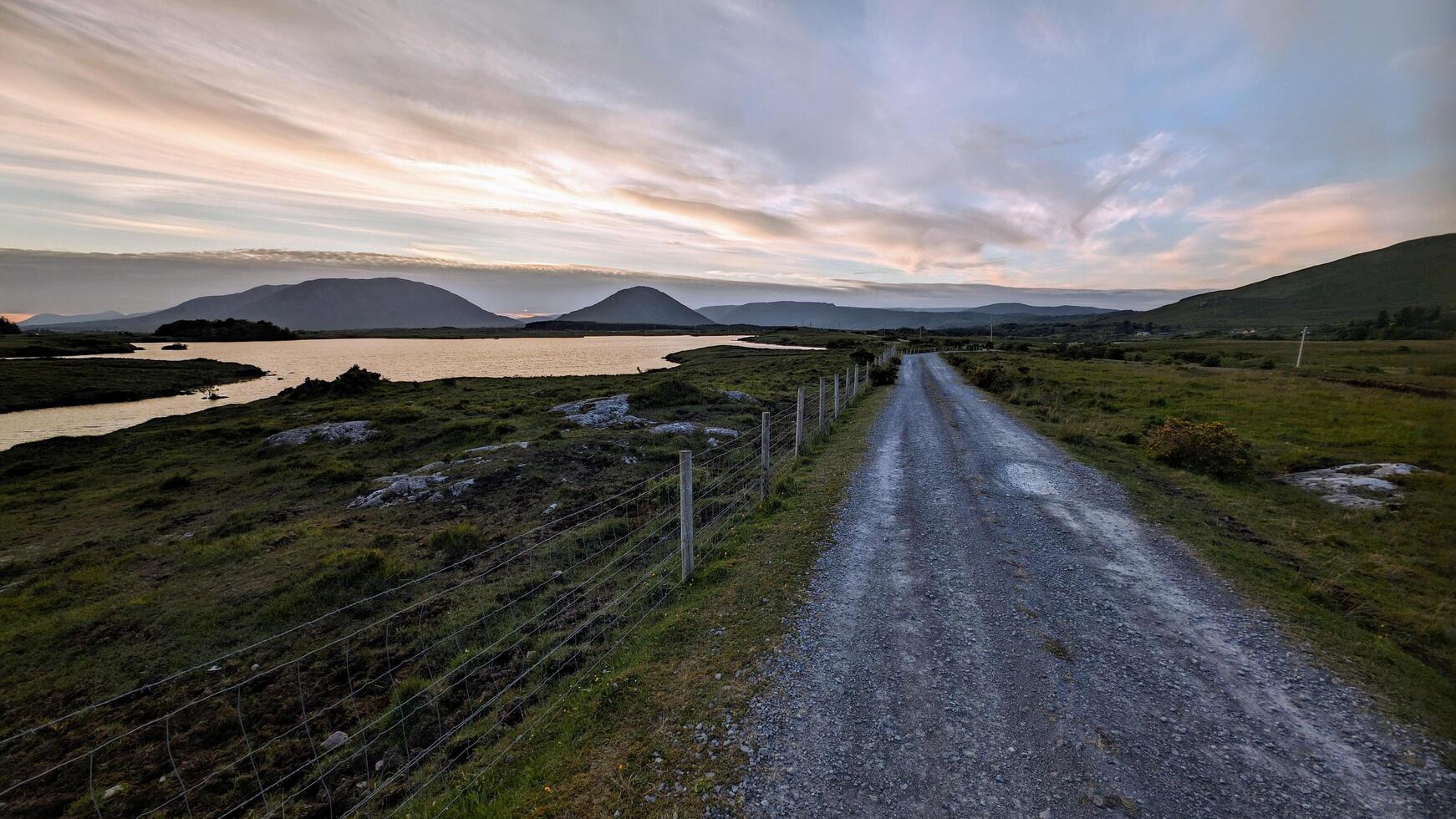Empty rural road by lake and mountains at Connemara national park, Galway, Ireland photo
