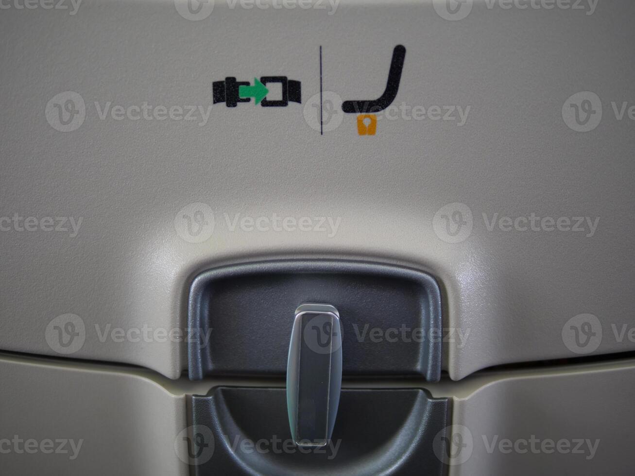 Table tray in plane closed on latch, pattern to fasten visible. Perfect for aviation and travel content table tray function and design in aircraft Experience convenience with table tray during flight. photo