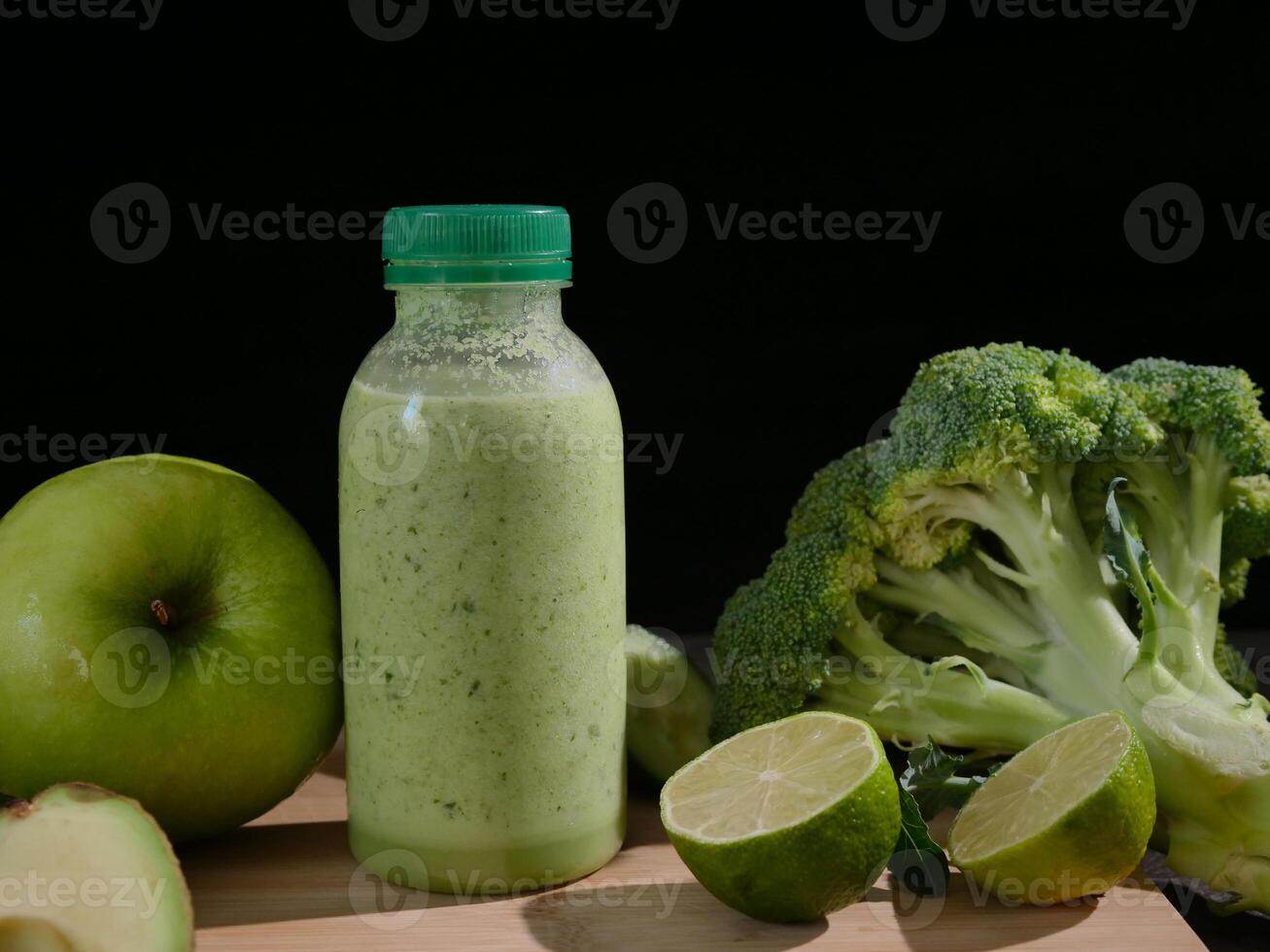 Fresh green smoothie in bottle surrounded by avocado, lime, broccoli, apple cucumber.Ideal for smoothie enthusiasts healthy eating and wellness videos Boost your content with this nutritious smoothie. photo