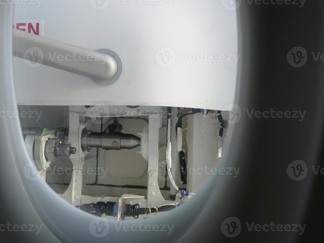 Through aircraft window on passenger seat, details of door visible. Perfect for travel and aviation content. Window view showing aircraft interior and door perspective through window during flight. photo