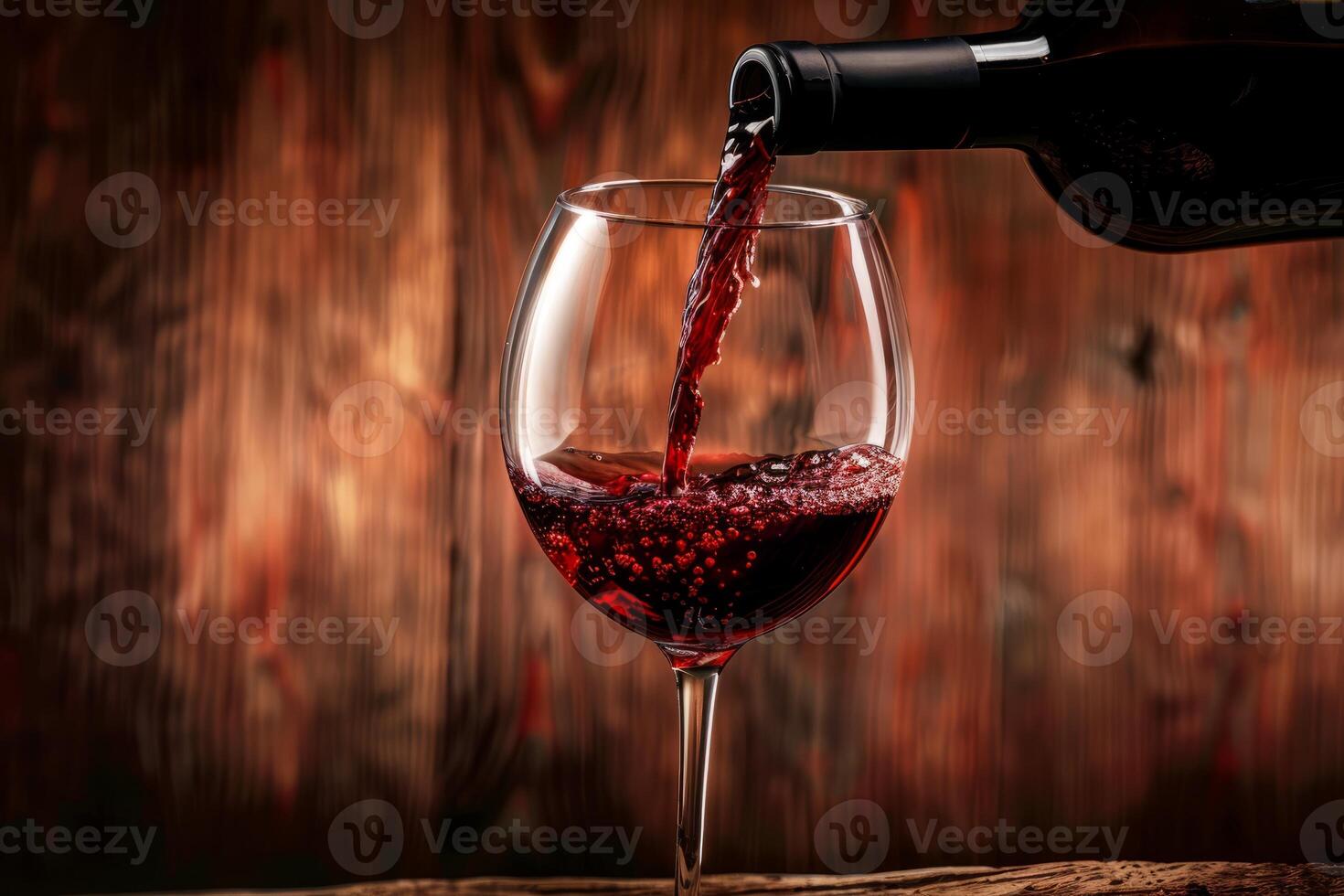 Pouring red wine into a glass with a wooden background photo