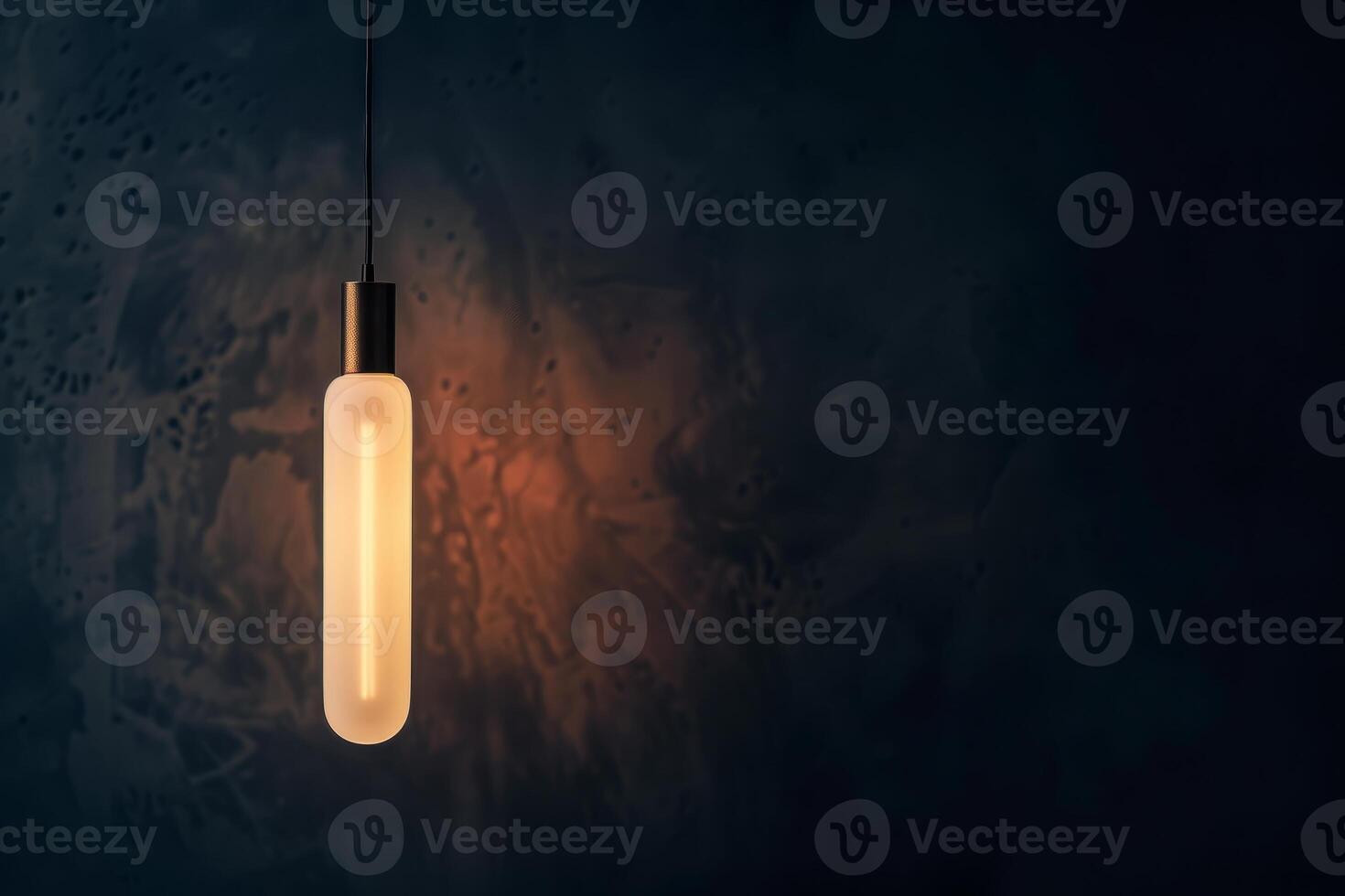Opaque tubular energy-saving bulb glowing in a minimalist loft-style fixture against a dark wall photo