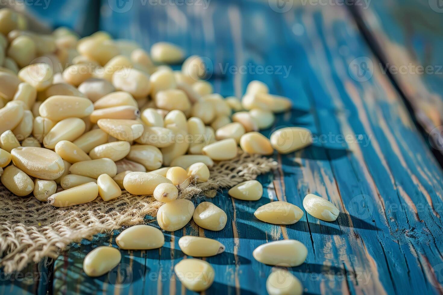 Pine nuts scattered on a rustic blue wooden surface photo