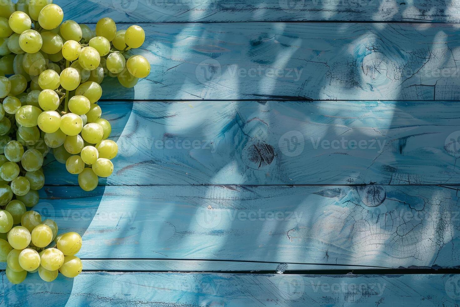 Green grapes on a blue rustic wooden background photo