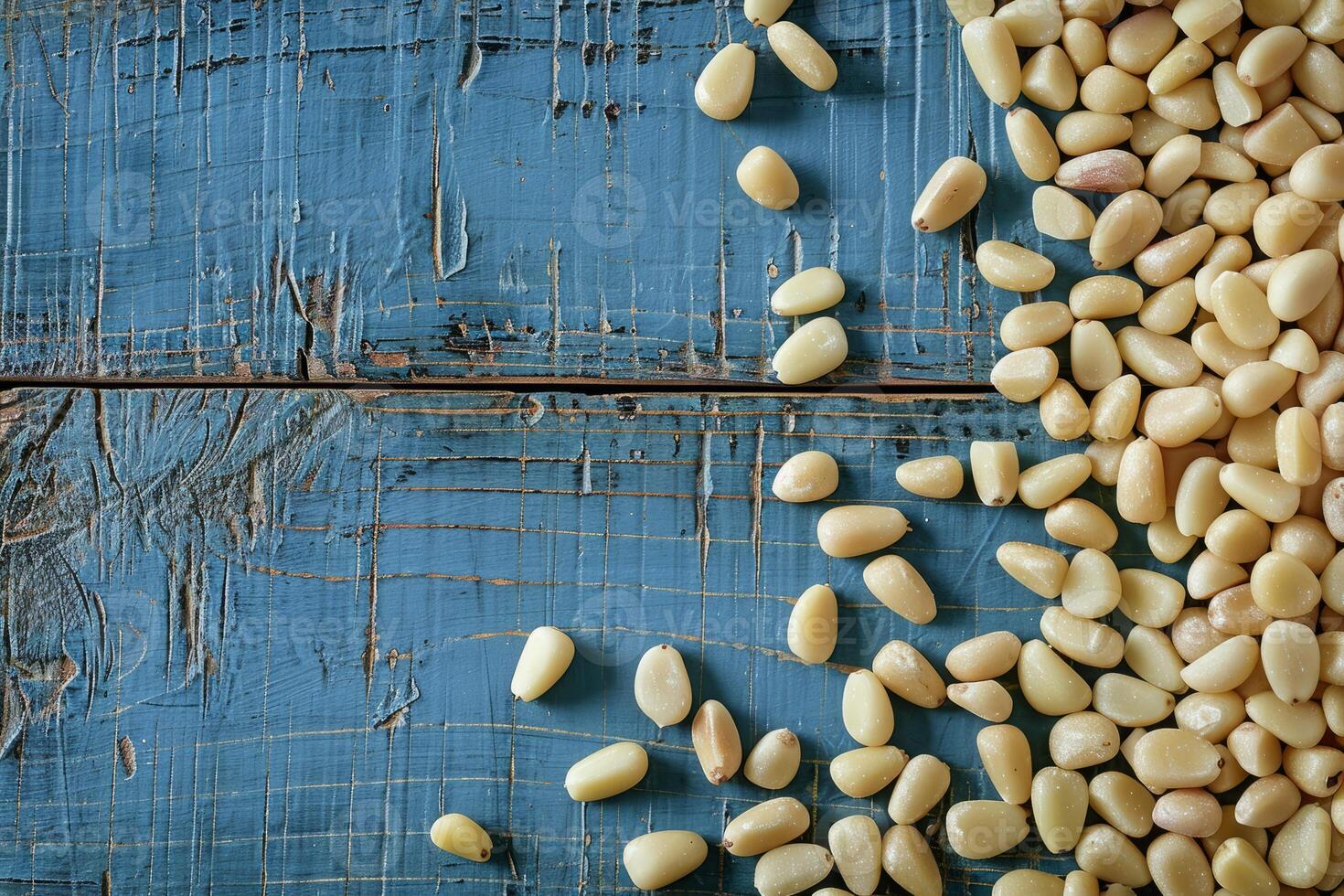 Pine nuts scattered on a rustic blue wooden surface photo