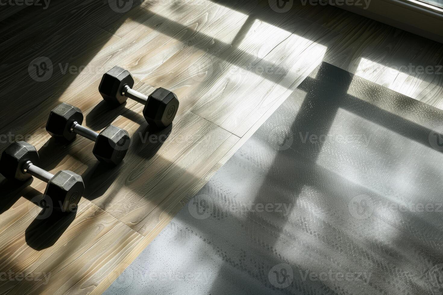 Dumbbells lie on the floor next to a yoga mat photo