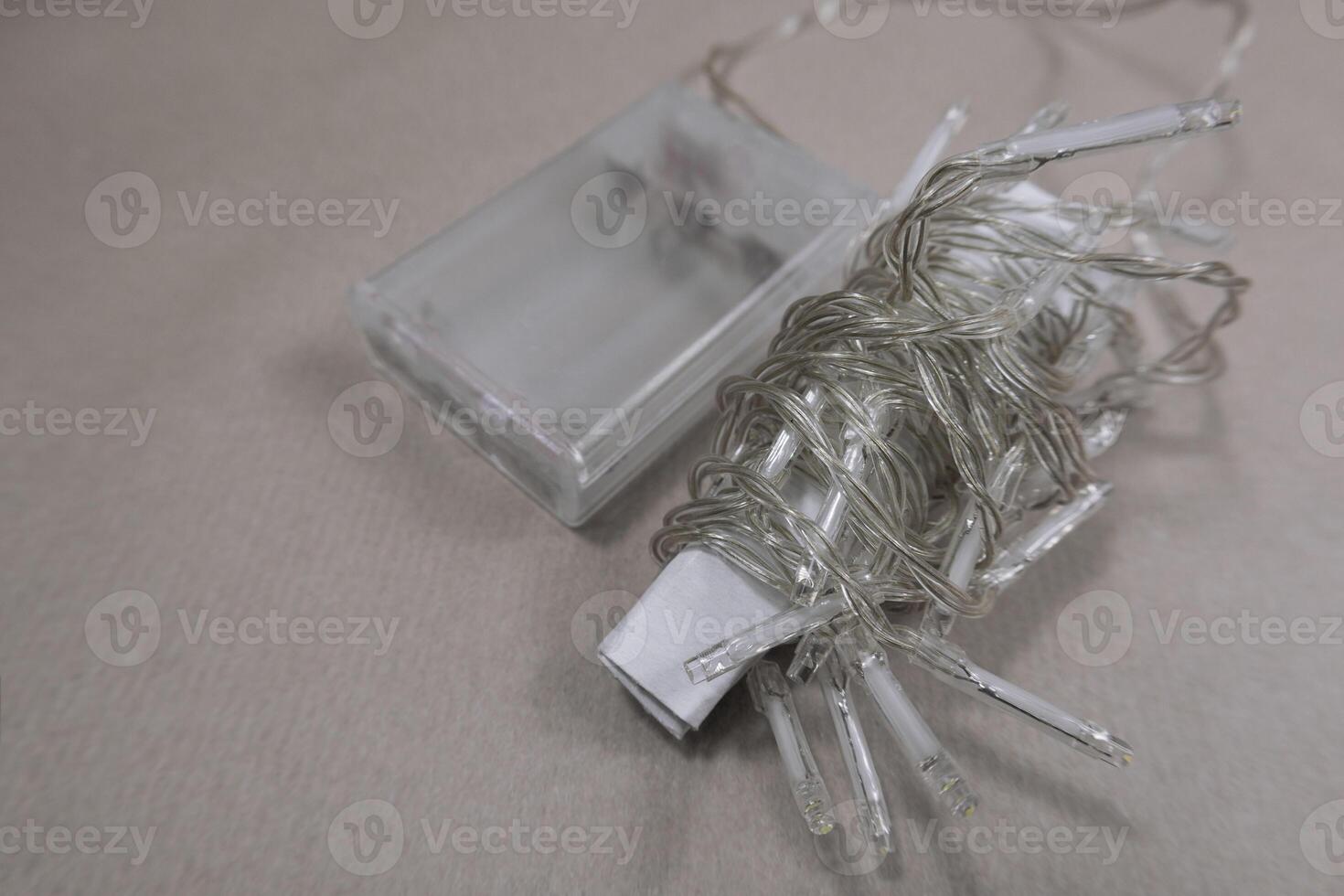 Selective focus flat lay string Christmas lights storage. Neatly wrapped up garland on background photo