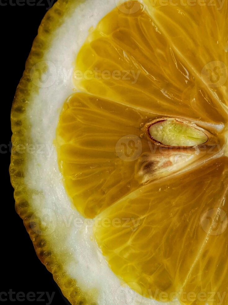 Lemon cut. Lemon slice with seed on a black background photo