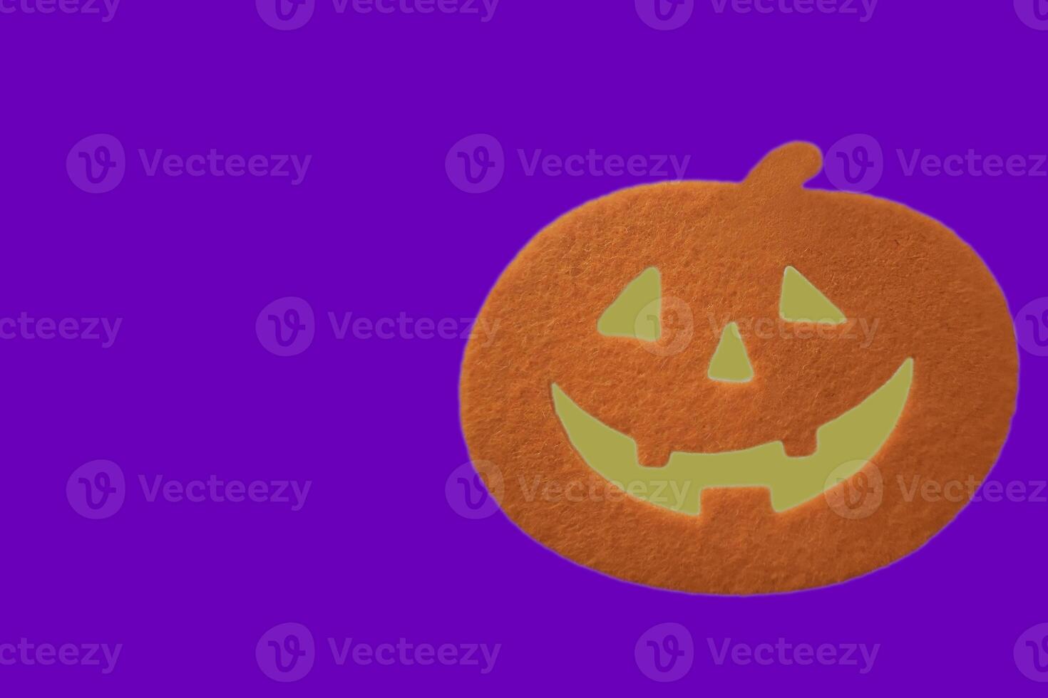 Closeup Halloween orange pumpkin on violet background with copy space for text. Halloween concept. photo