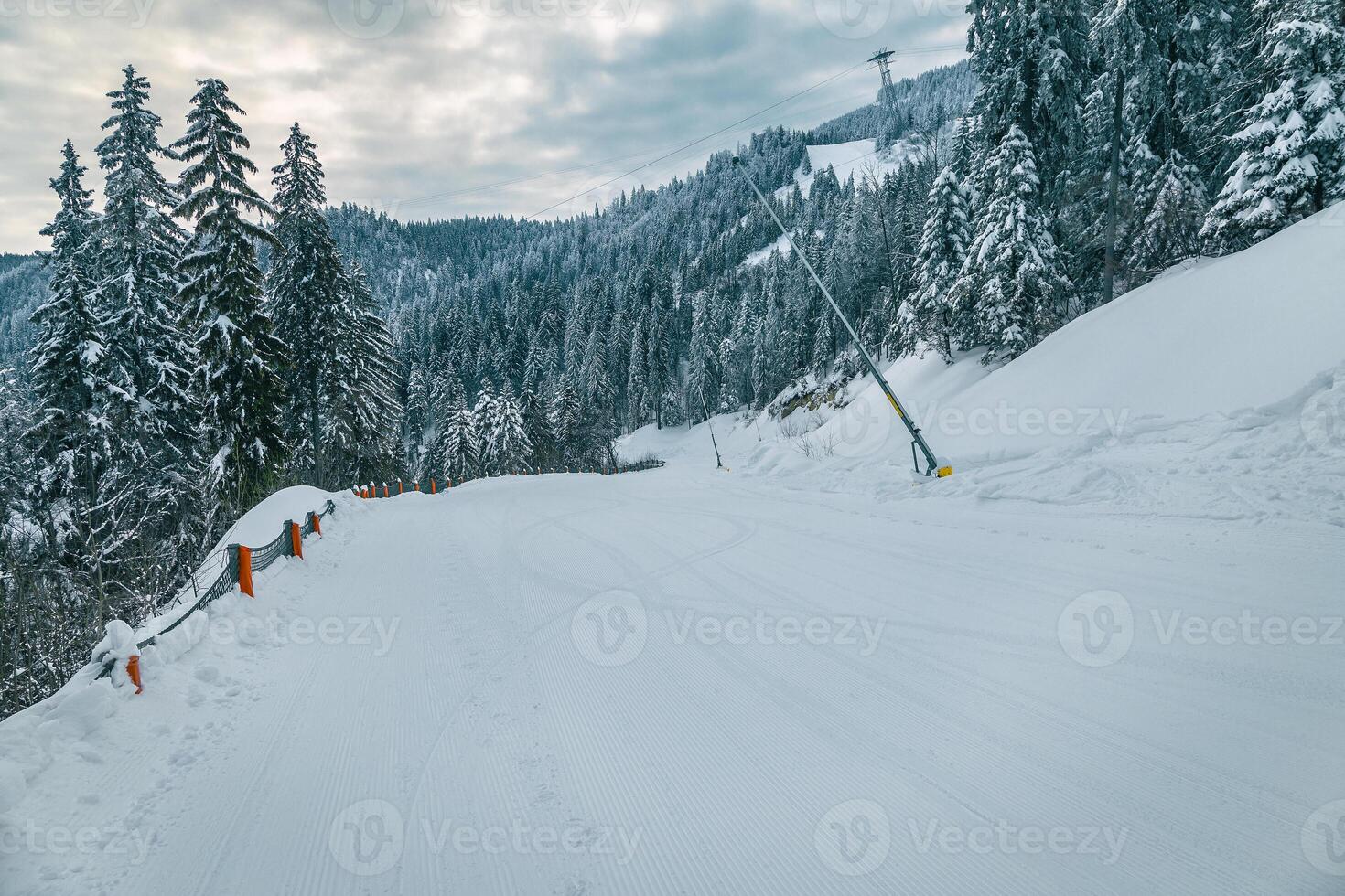 Prepared ski slope with snow cannons photo