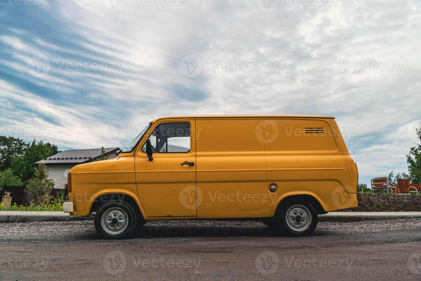A yellow Ford van parked on a residential street. photo