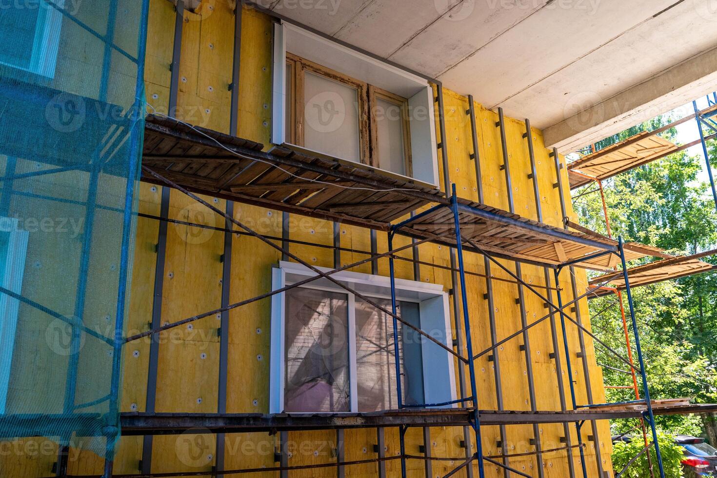 A close-up of a building exterior with insulation and scaffolding photo