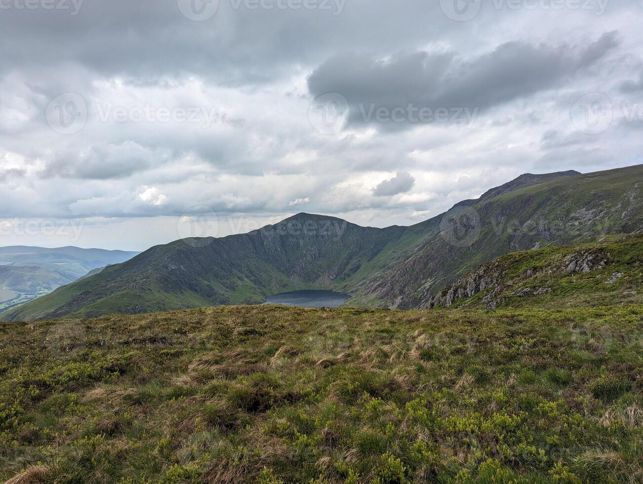 Scenic Mountain Landscape Under Moody Sky with Green Hills and Valleys photo
