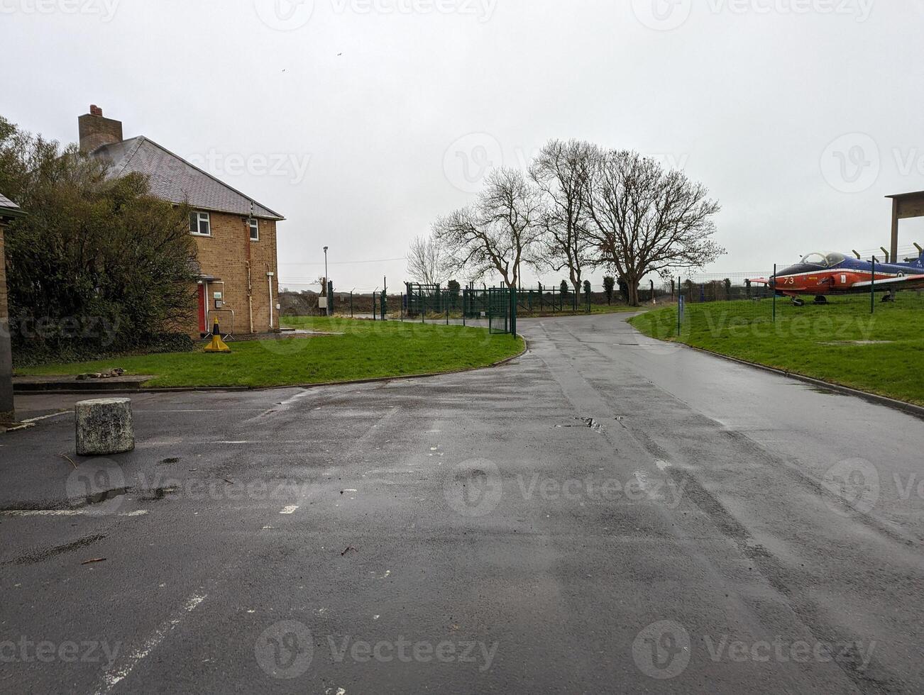 Residential building with a wet driveway and grass photo