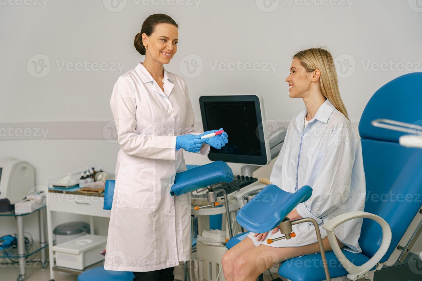 Female doctor showing positive pregnancy test for a pregnant woman at medical clinic photo