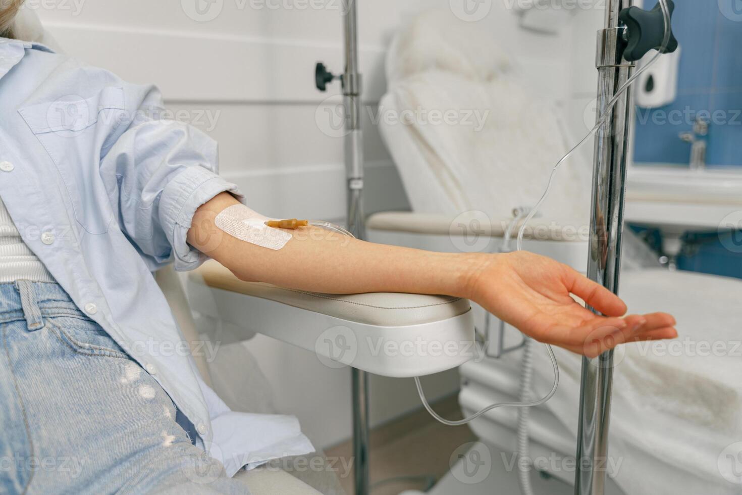Close up of woman patient hand with medical drip or IV drip in hospital ward. Healthcare concept photo