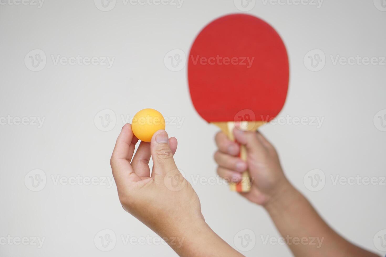 Selective focus on the orange ball on hand with serving table tennis racket. Concept, sport equipment. Exercise or workout tool. Competitive game sport. Playing Ping pong photo