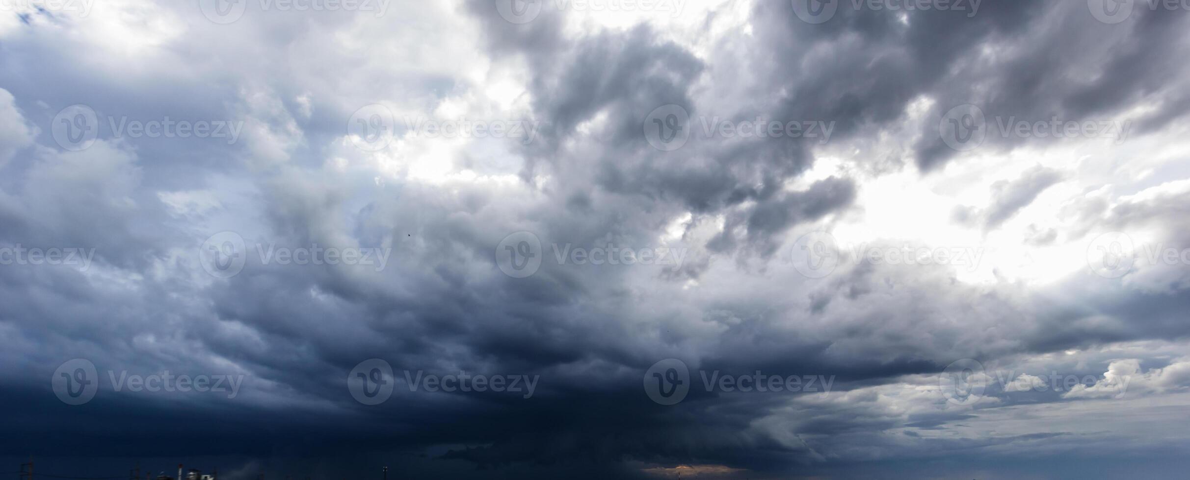 The dark sky with heavy clouds converging and a violent storm before the rain.Bad or moody weather sky and environment. carbon dioxide emissions, greenhouse effect, global warming, climate change photo