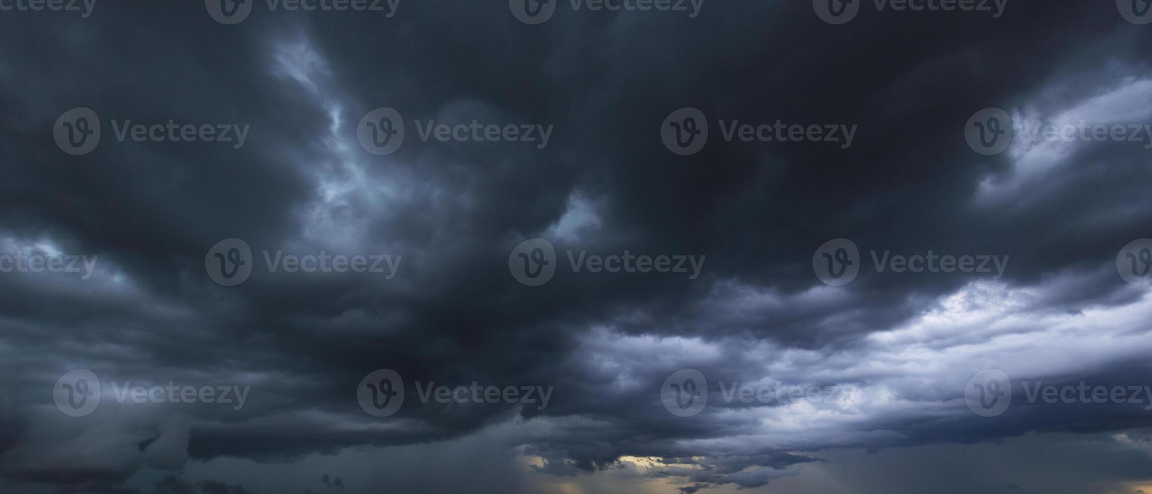 The dark sky with heavy clouds converging and a violent storm before the rain.Bad or moody weather sky and environment. carbon dioxide emissions, greenhouse effect, global warming, climate change photo
