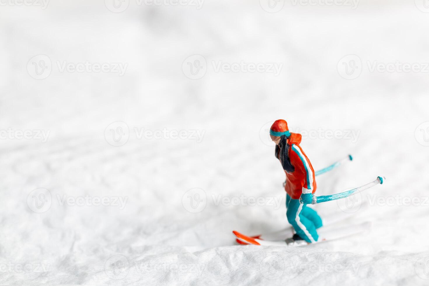 A miniature figurine of a skier dressed in vibrant winter gear. This image is perfect for themes related to winter sports photo