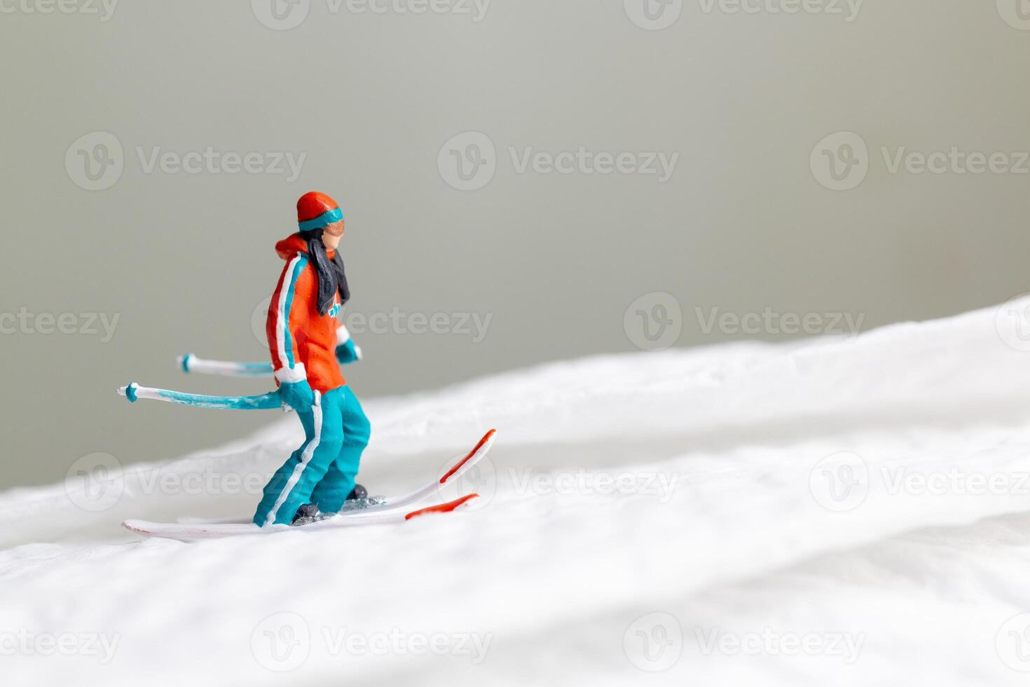 A miniature figurine of a skier dressed in vibrant winter gear. This image is perfect for themes related to winter sports photo
