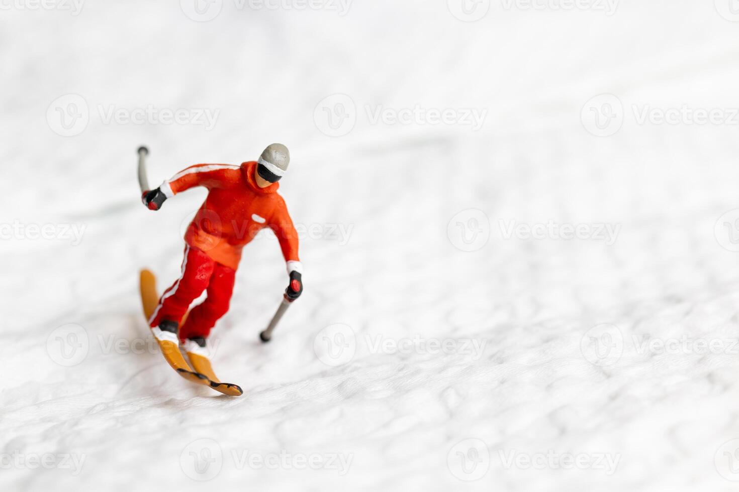 A miniature figurine of a skier dressed in vibrant winter gear. This image is perfect for themes related to winter sports photo