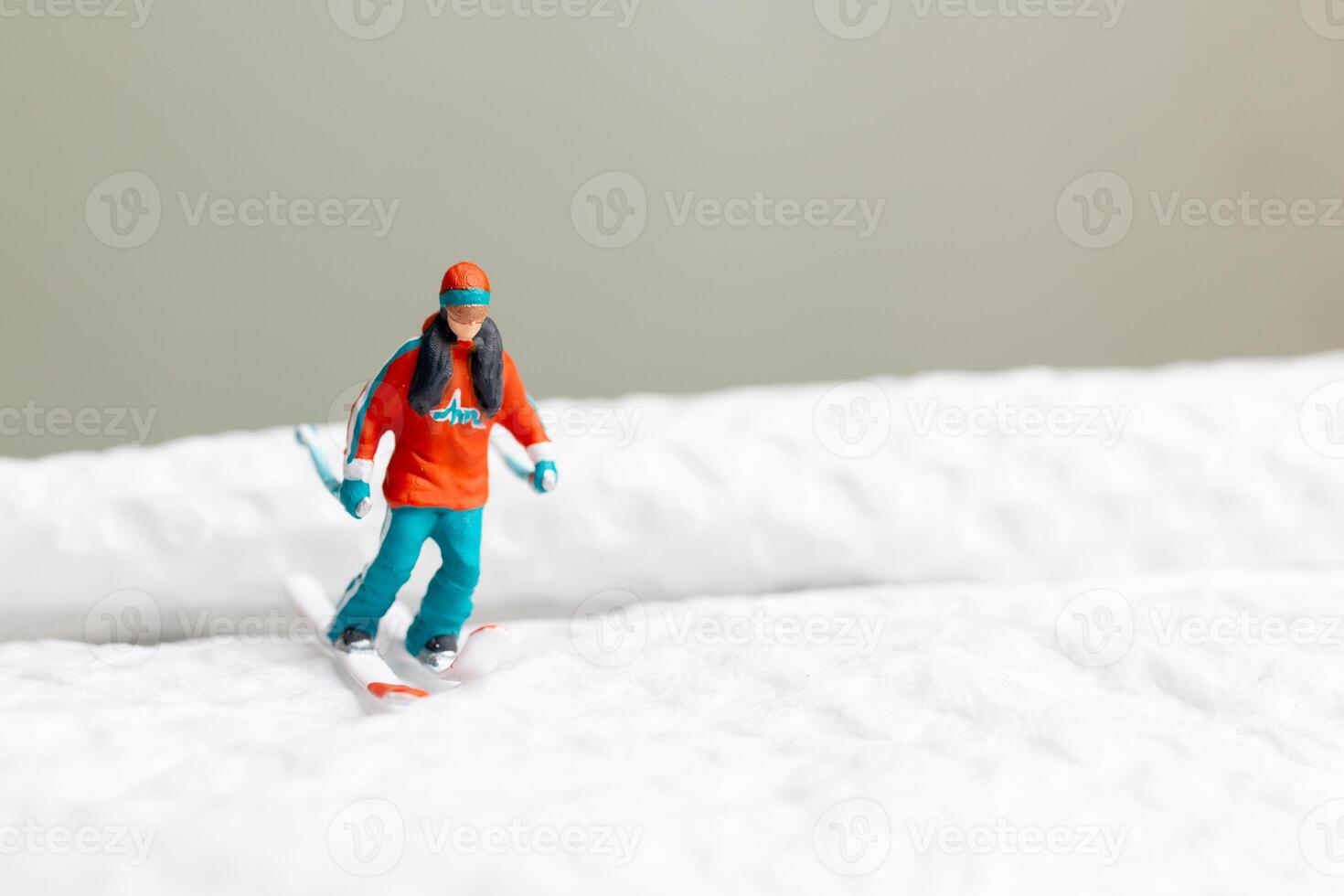 A miniature figurine of a skier dressed in vibrant winter gear. This image is perfect for themes related to winter sports photo