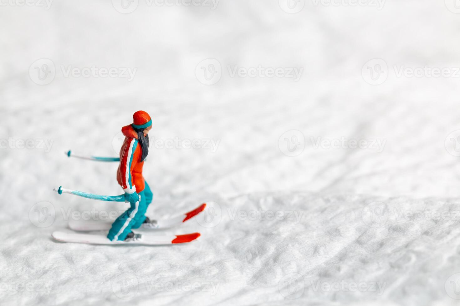 A miniature figurine of a skier dressed in vibrant winter gear. This image is perfect for themes related to winter sports photo