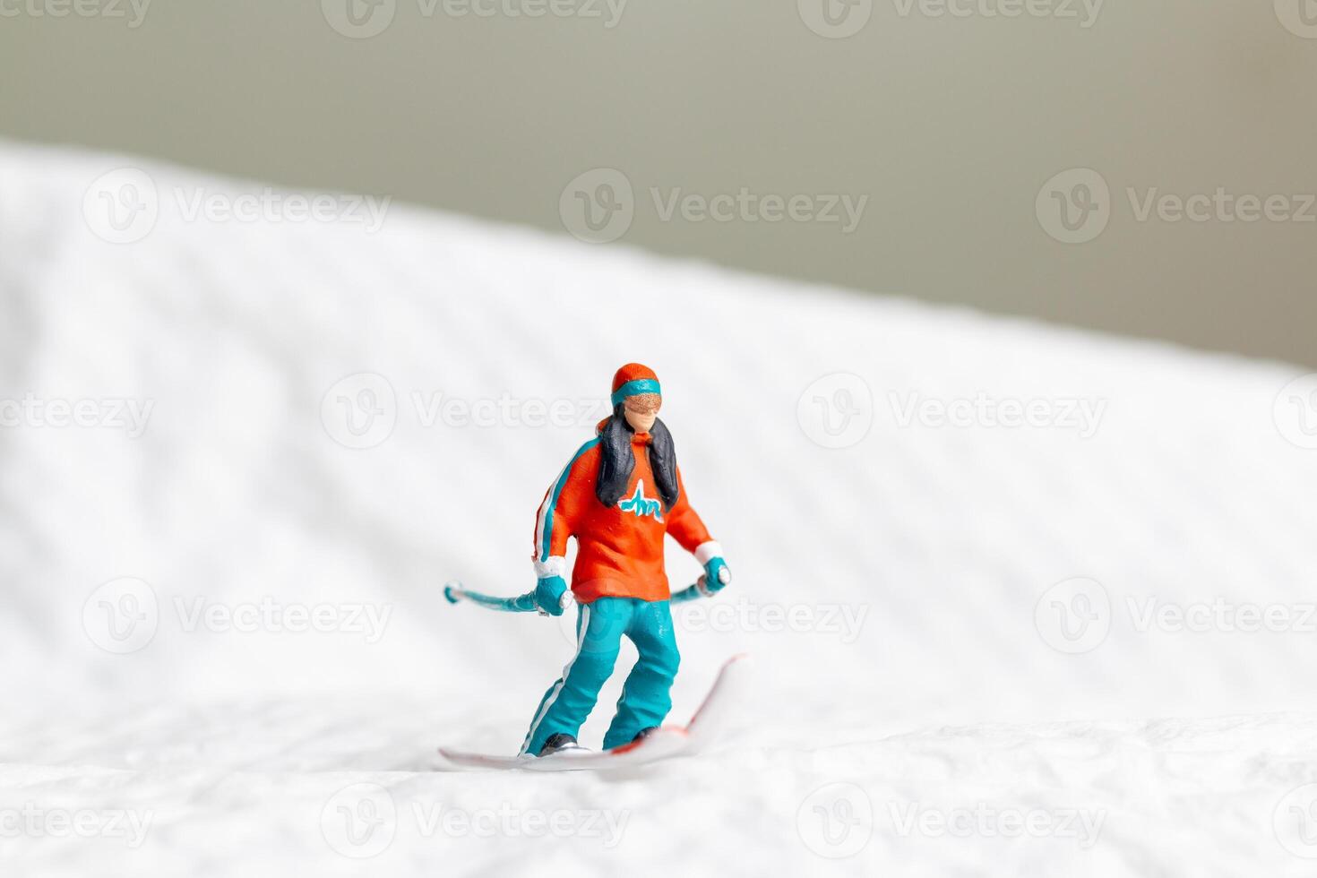 A miniature figurine of a skier dressed in vibrant winter gear. This image is perfect for themes related to winter sports photo
