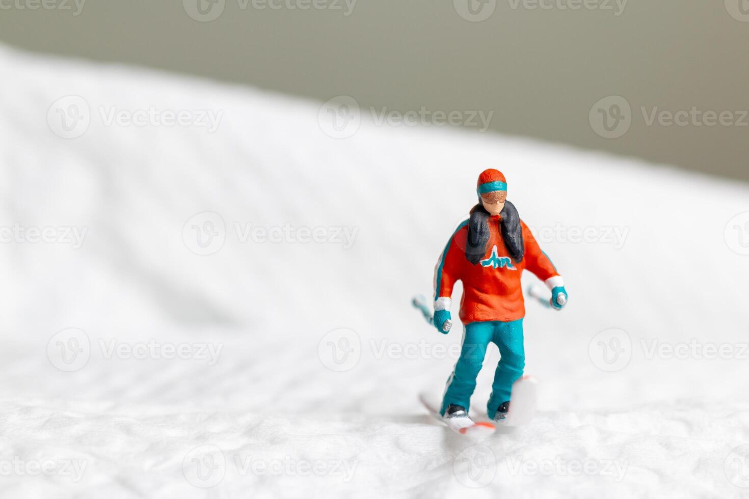 A miniature figurine of a skier dressed in vibrant winter gear. This image is perfect for themes related to winter sports photo