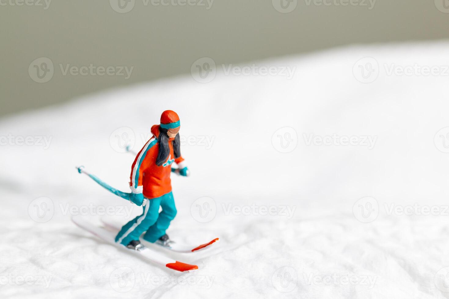 A miniature figurine of a skier dressed in vibrant winter gear. This image is perfect for themes related to winter sports photo