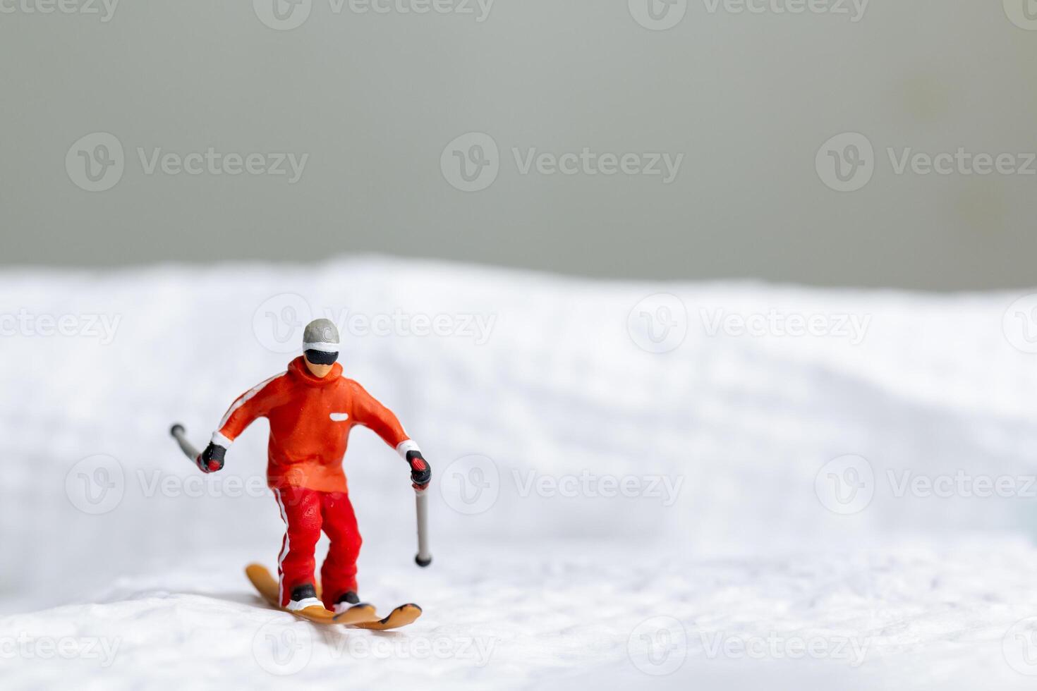 A miniature figurine of a skier dressed in vibrant winter gear. This image is perfect for themes related to winter sports photo