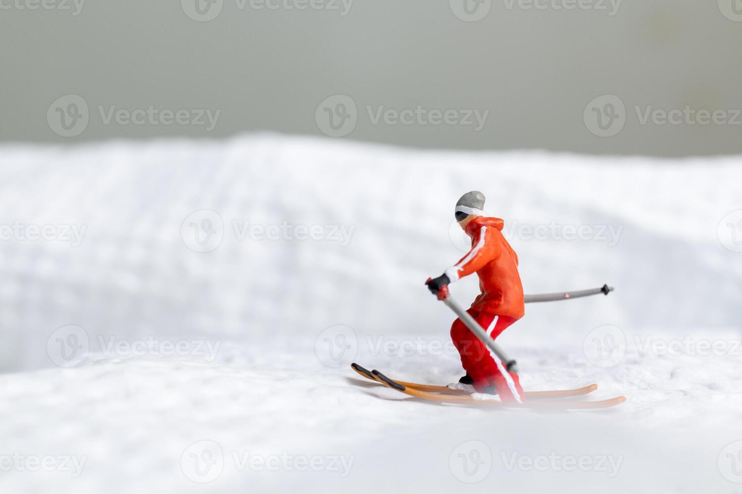 A miniature figurine of a skier dressed in vibrant winter gear. This image is perfect for themes related to winter sports photo