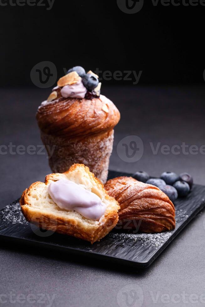 Blueberry Meringue Muffins Waffles with bread, vanilla cream and fork served on board isolated on dark background side view of baked cafe food photo