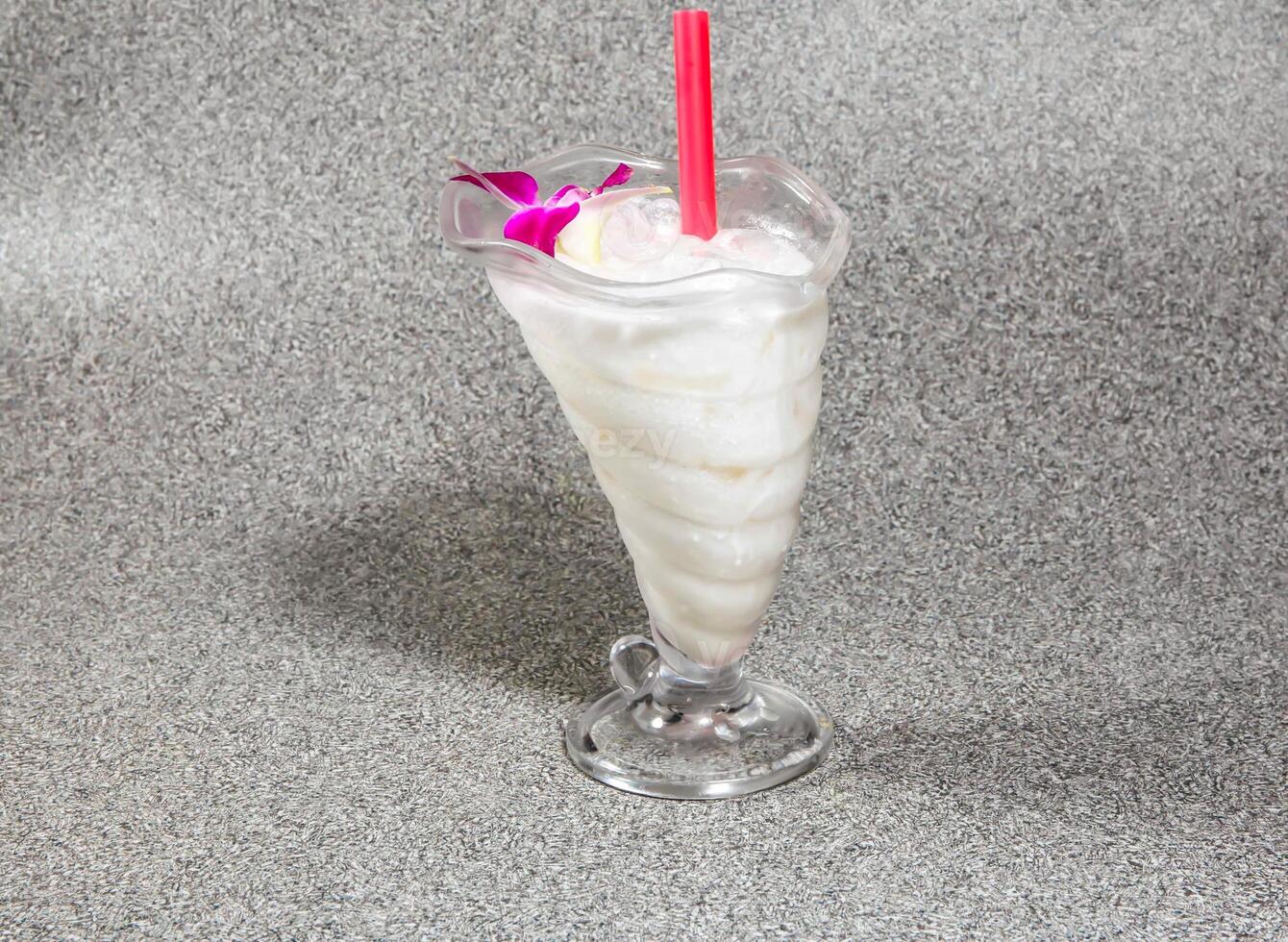 iced coconut milk with straw served in glass isolated on grey background side view of hong kong dessert drink photo