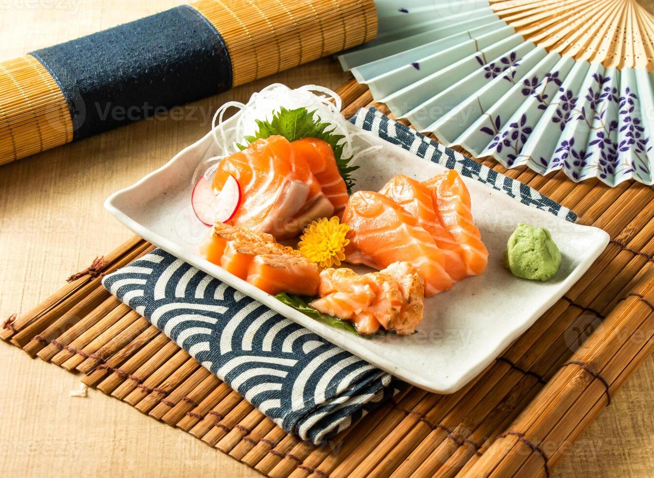 salmon sashimi with salad served in dish isolated on napkin side view on wooden background of Japanese food photo