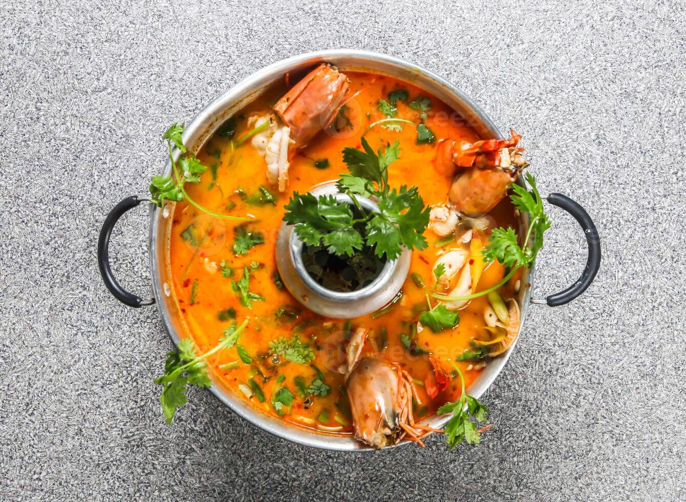 spicy tom yam soup with king shrimps served in broth isolated on grey background top view of hong kong fastfood photo