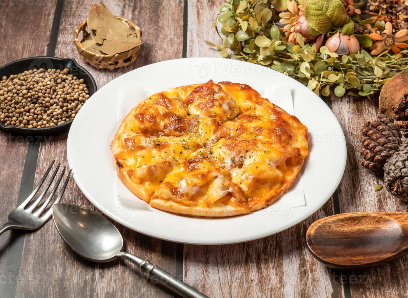 hawaiian pizza with spoon and fork served in plate isolated on wooden table side view of taiwan fasfood photo