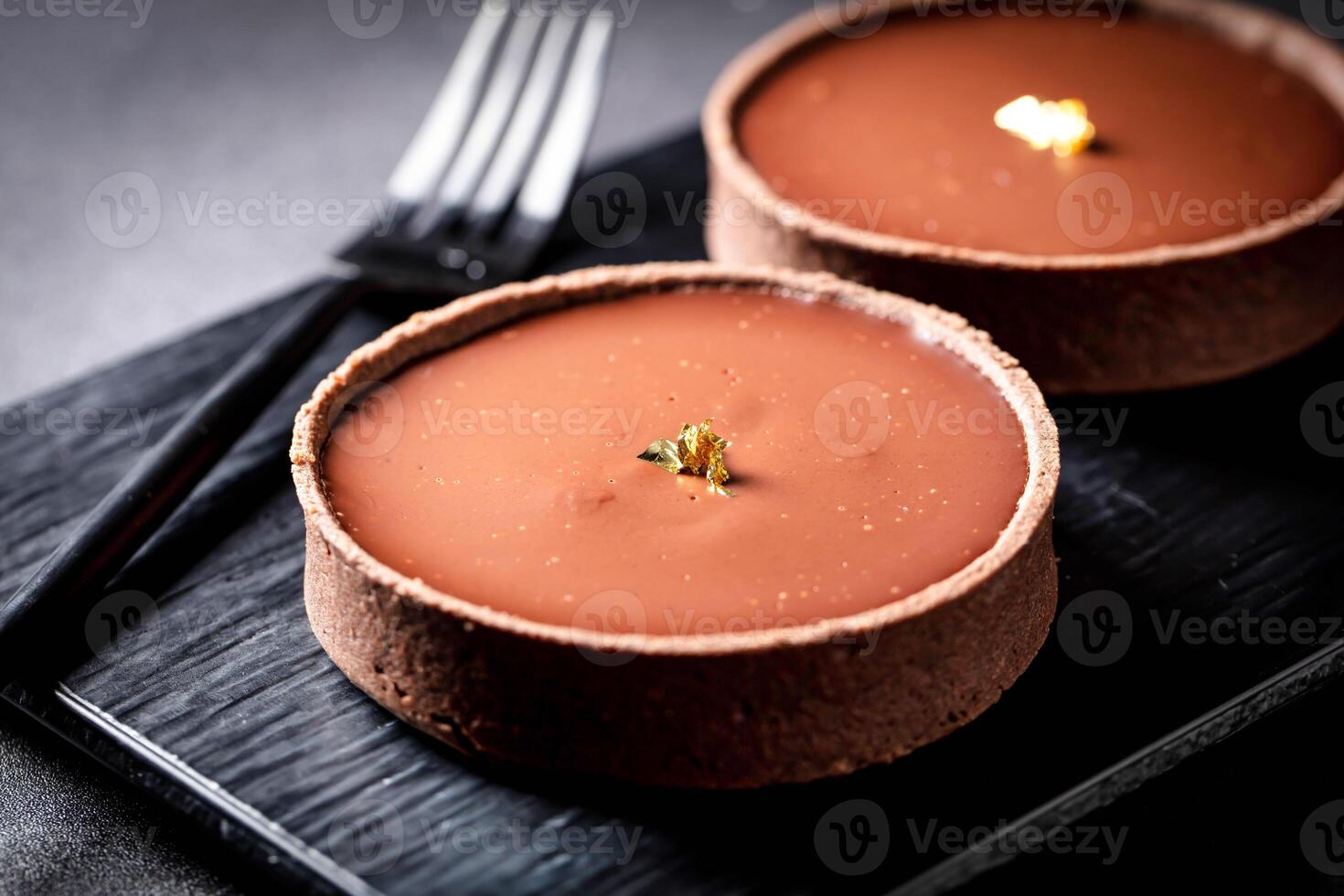 Chocolate Tart round with fork served in dish isolated on dark background side view of baked cafe food photo